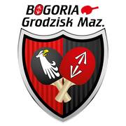 Logo grodziskiego klubu spotowego Bogoria- na tarczy dwie rakietki od pingponga , skrzyżowane jedna z herbem Grodziska, druga z głową białego orła na czarnym tle.