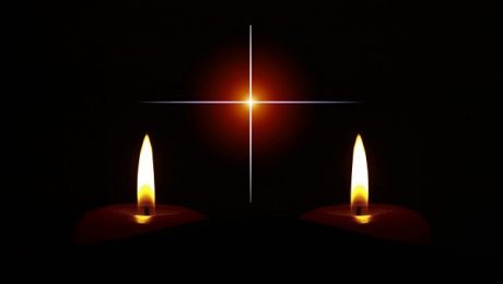 Dwie świece i krzyż na ciemnym tle