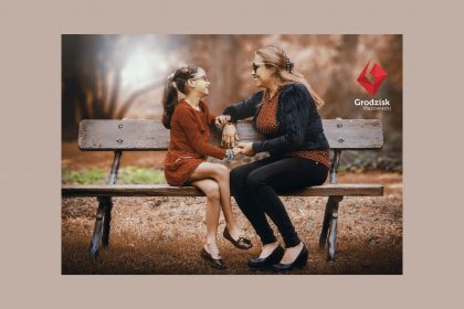 Matka z córką rozmawiają na ławce w parku