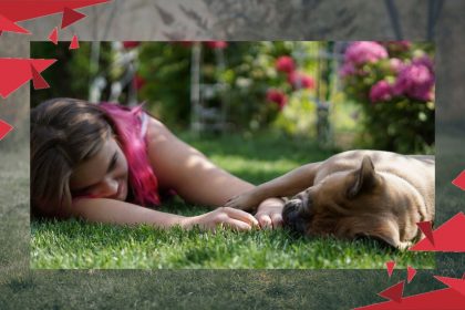 dziewczynka na trawie obok pies